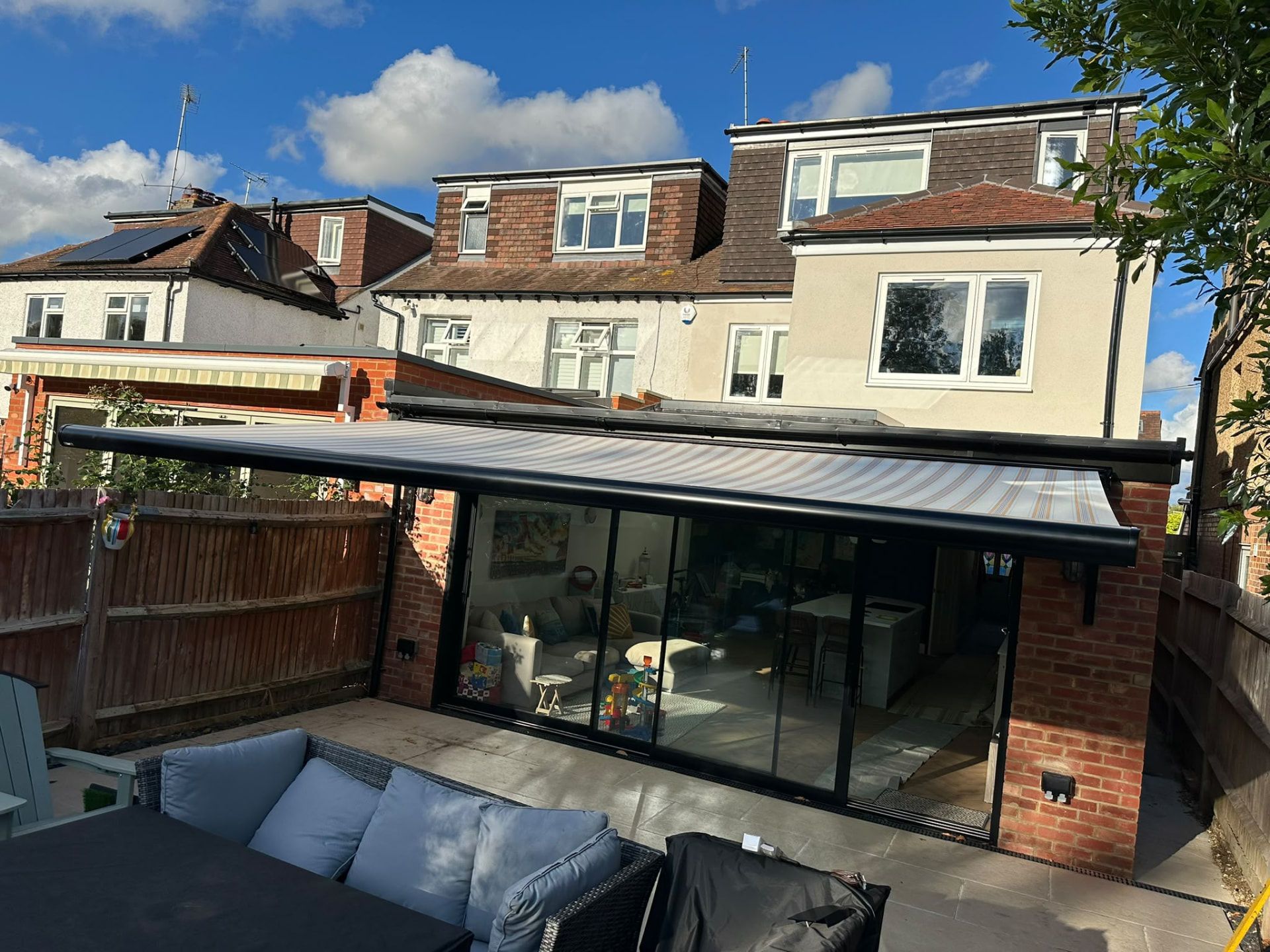 Harpenden patio with the black Aura Plus awning retracted above the doors