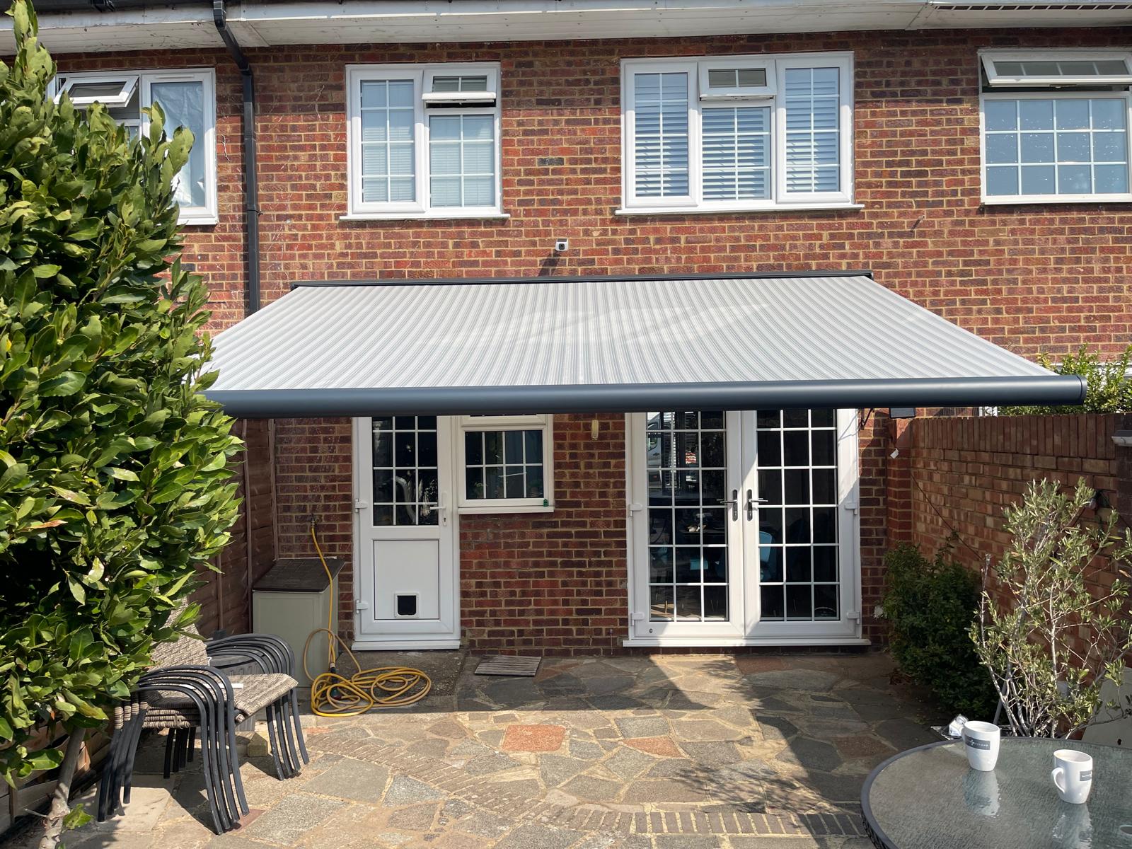Anthracite Aura Plus awning extended over a patio in Twickenham