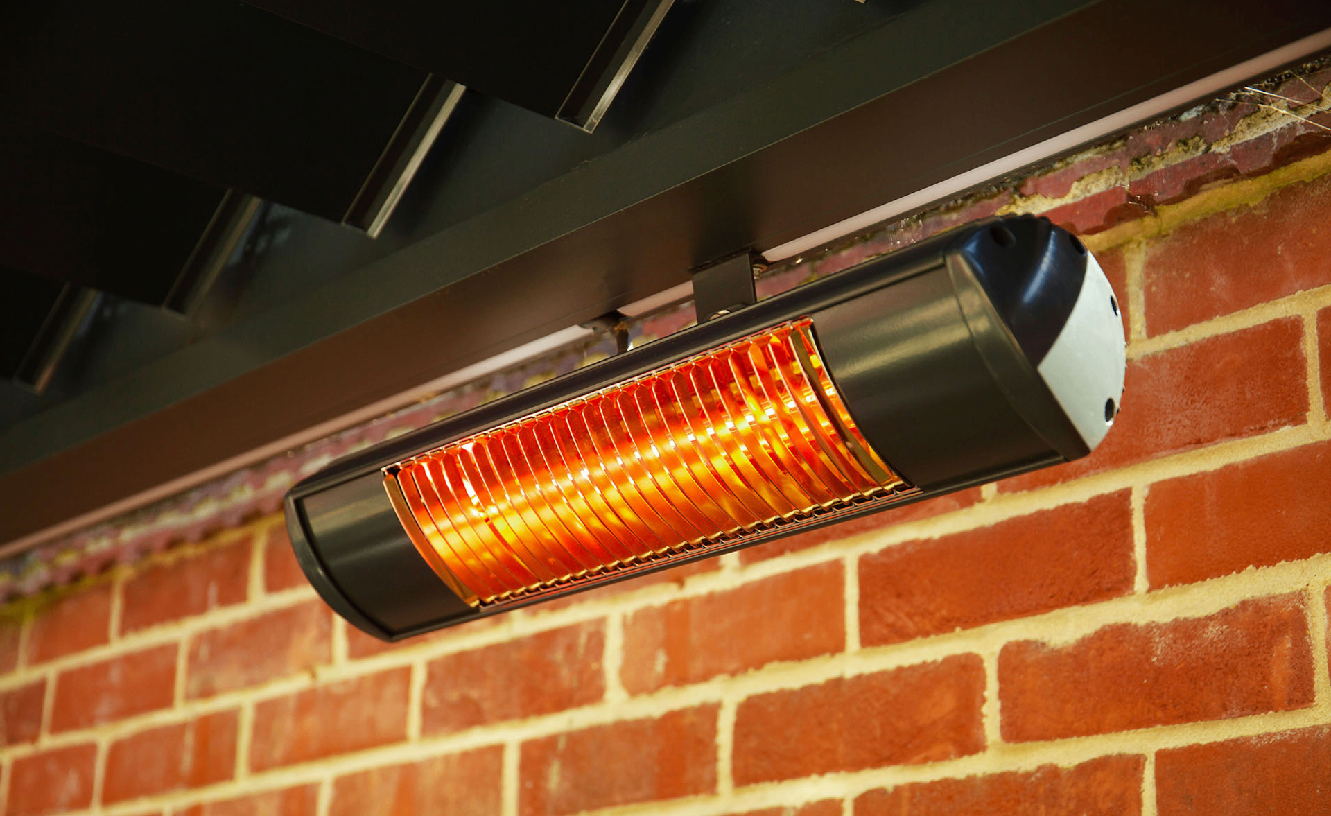 Infrared patio heater mounted under an awning against exposed brick