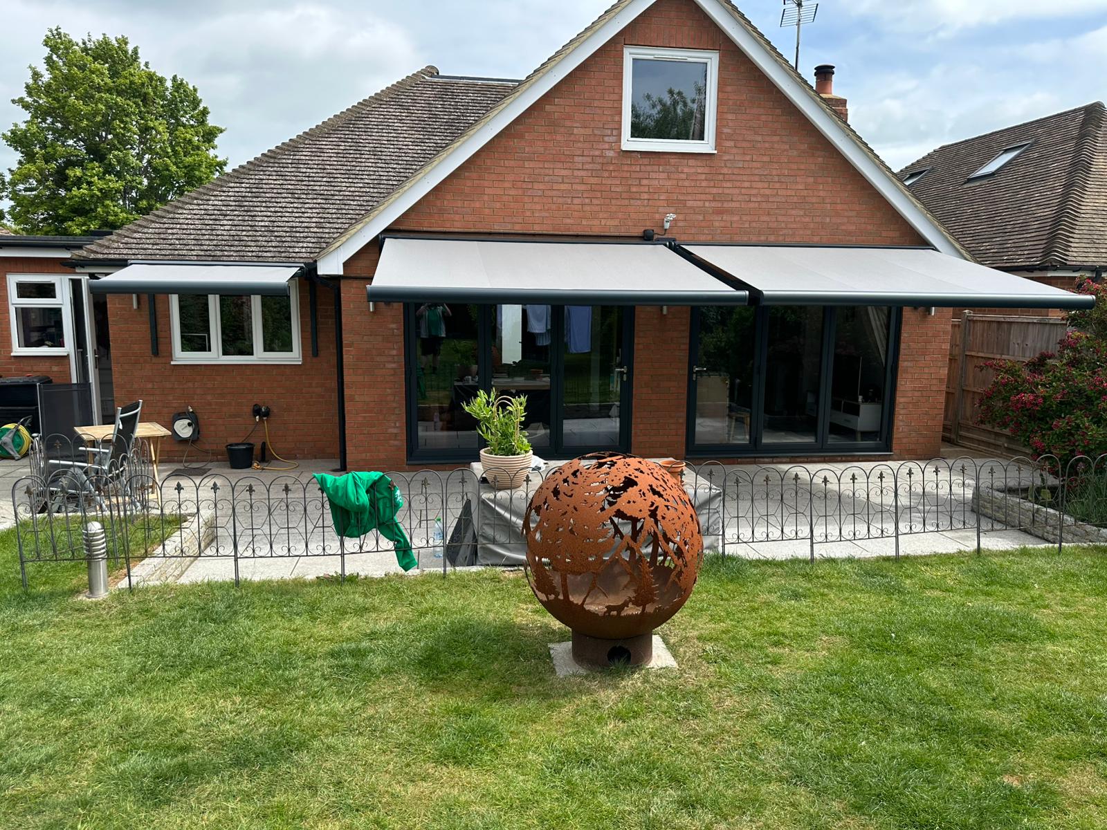 Two Aura Plus awnings fully extended over patio at Tring bungalow
