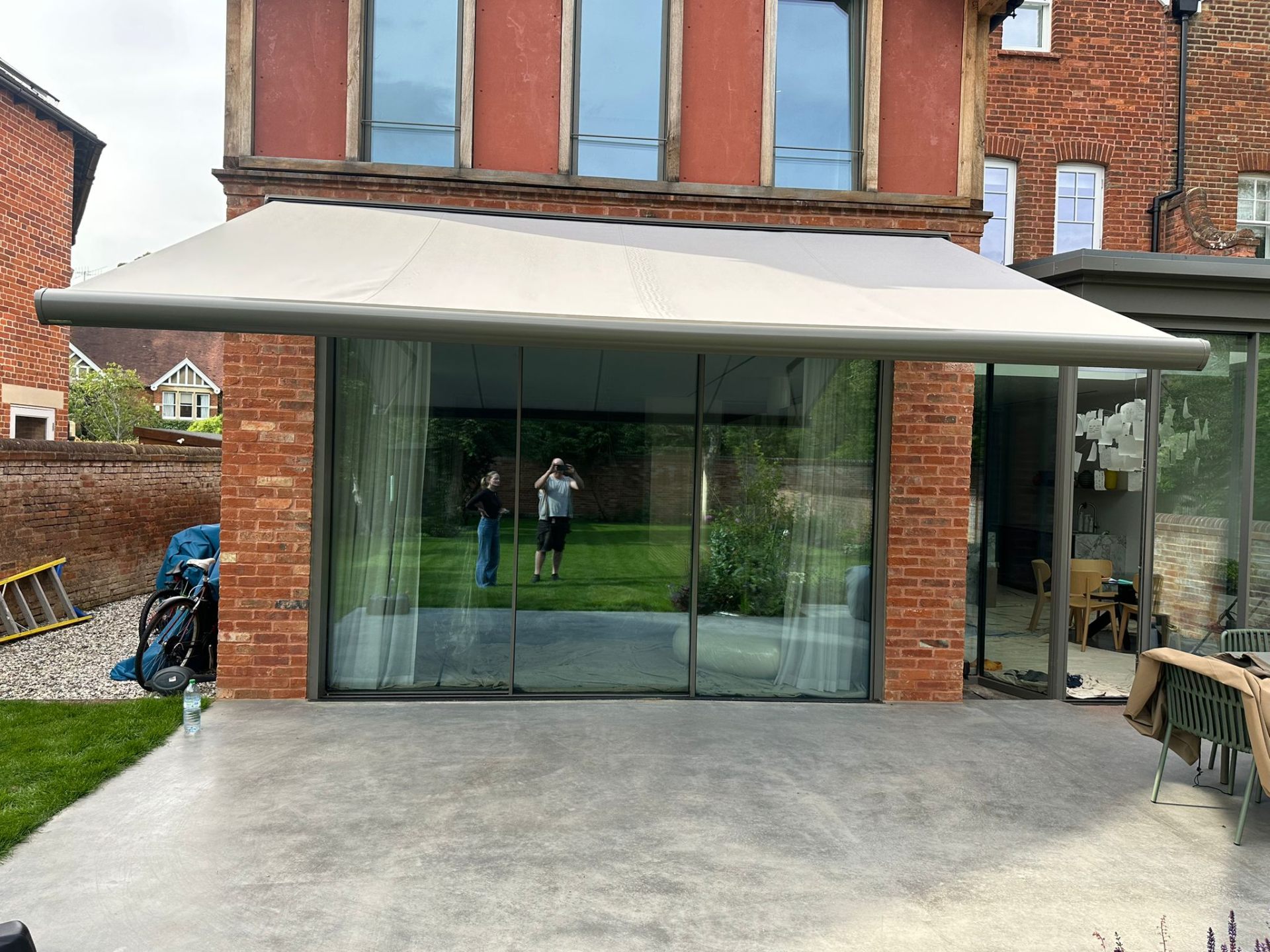 Aura Plus awning fully extended over sliding glass door at Oxford home