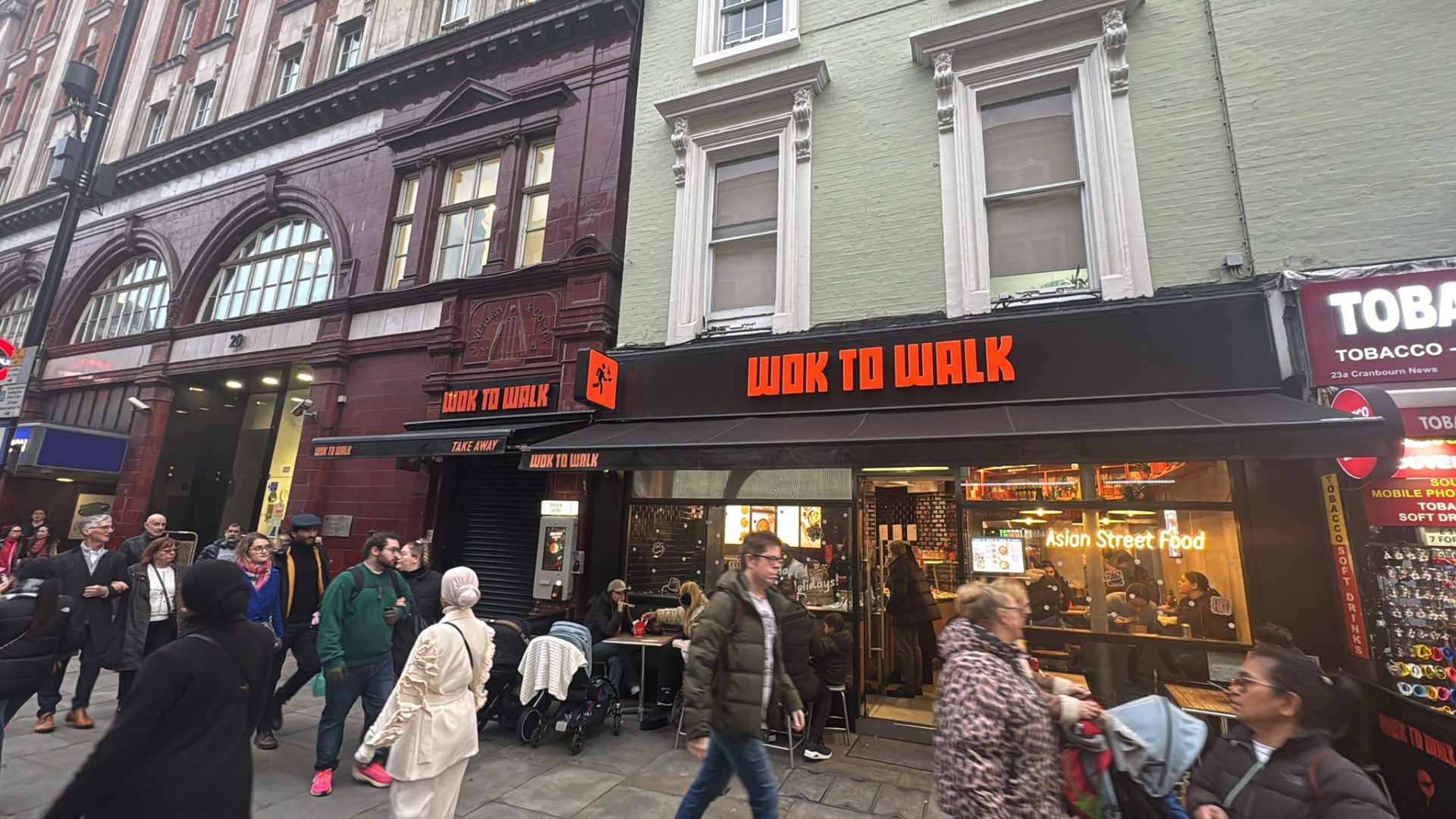 Motorised black Aura Plus with orange Wok to Walk branding on Cranbourn Street, London