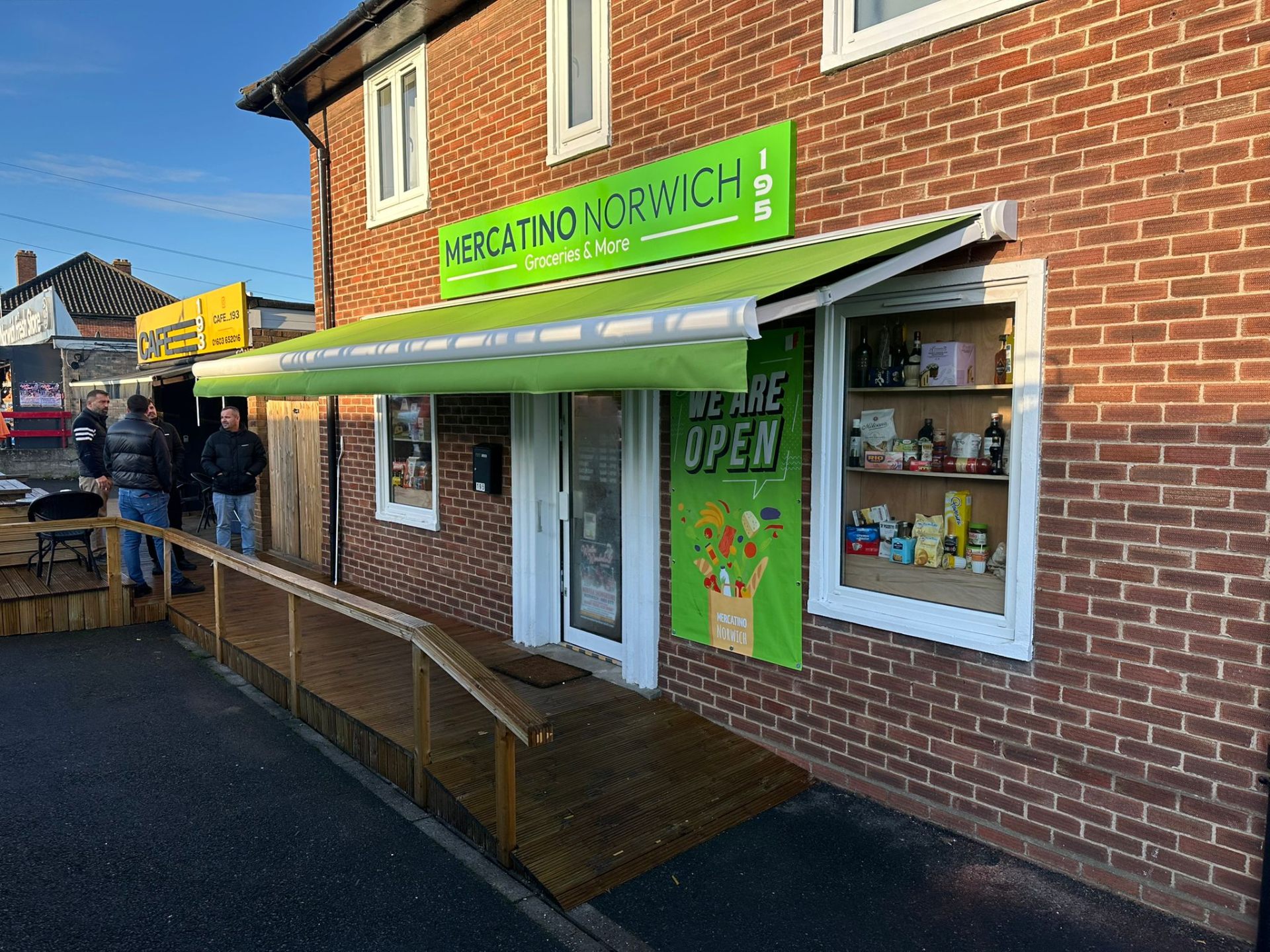Lime-green Aura Plus extended over the entrance of Mercatino Norwich