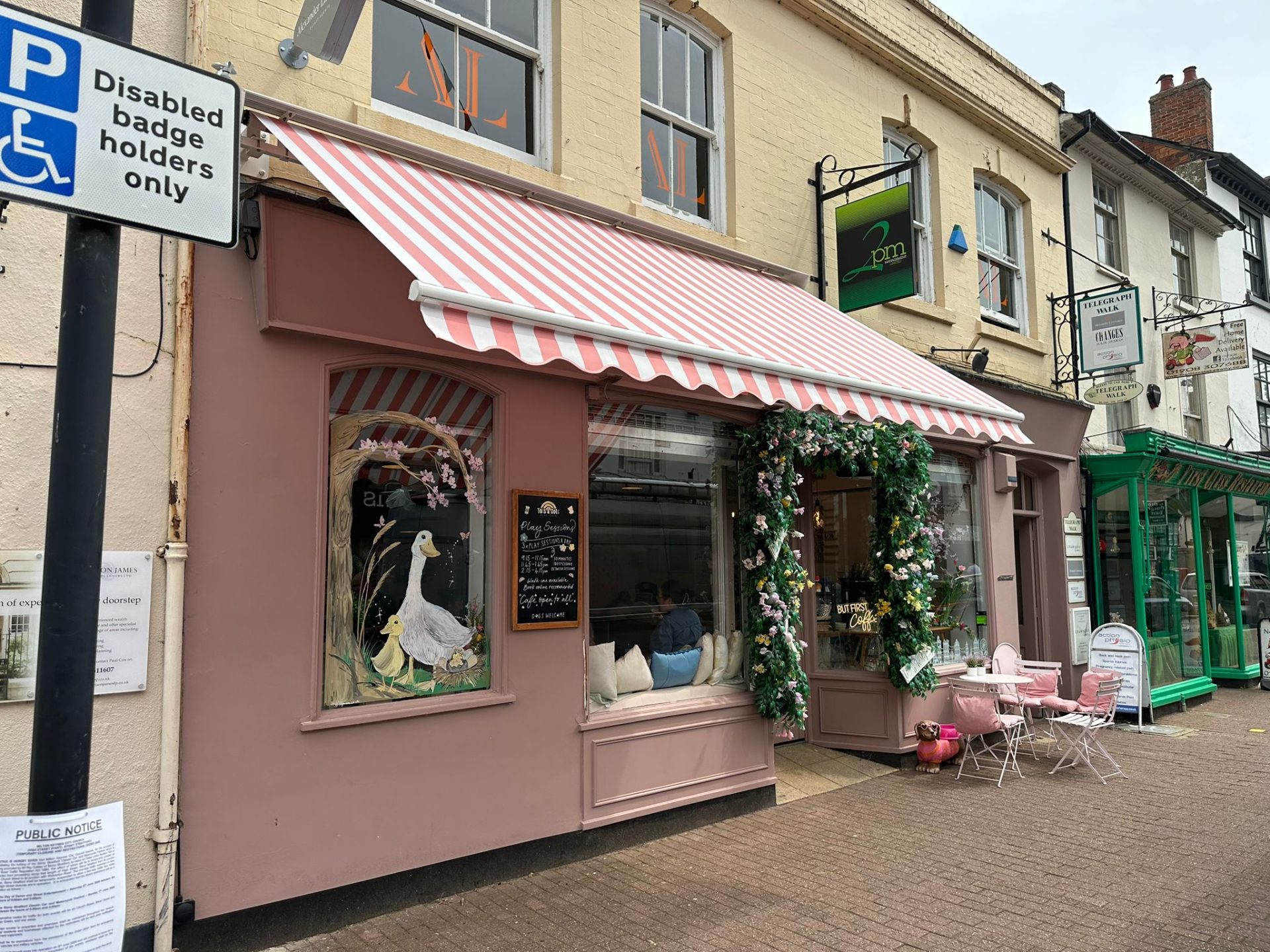 Pink and white striped Arezzo awning extended over Tots & Dots play cafe shopfront, Stony Stratford