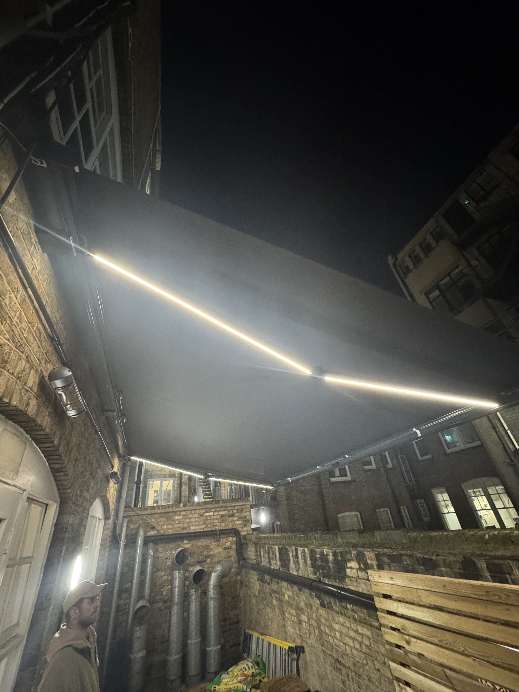 Motorised Armony extended at night with LED strip lighting illuminating a London courtyard